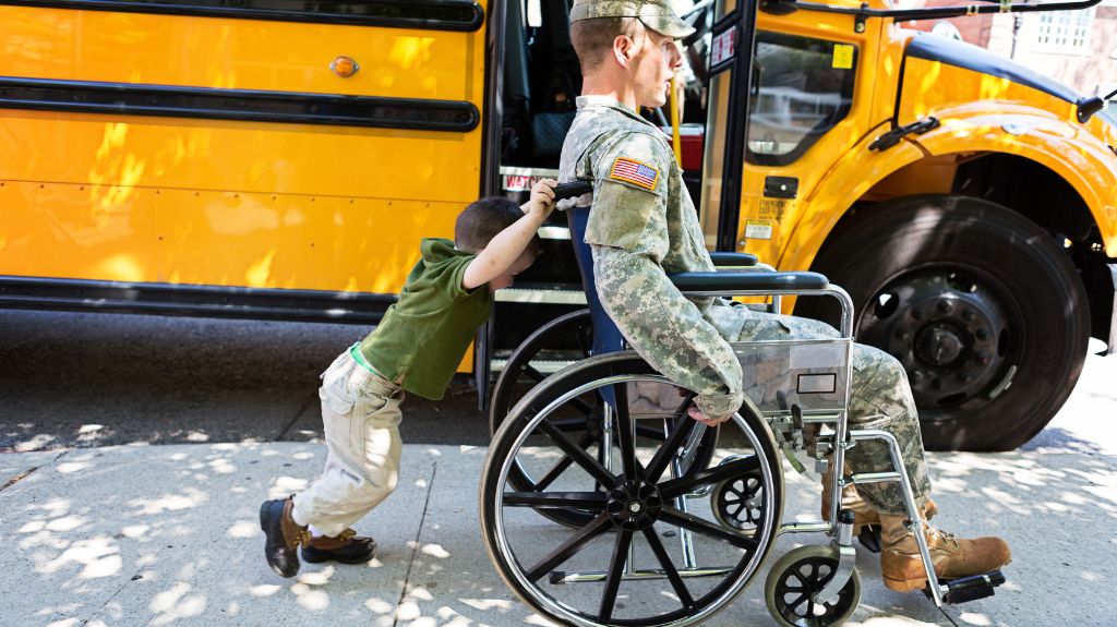 Child Pushing Veteran in a Wheelchair