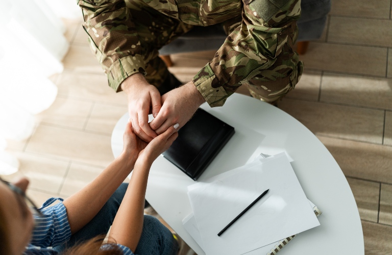 female doctor holding hands of military man