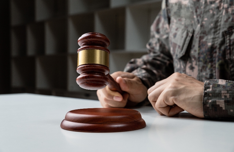 Hand of soldier holding judge's gavel